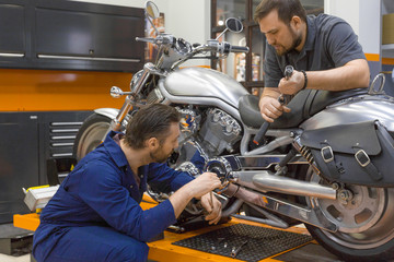Two men in a motorcycle workshop.