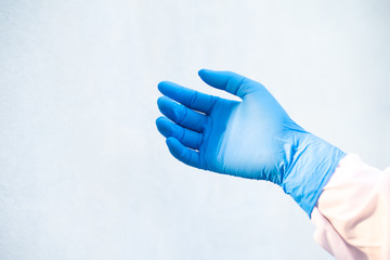 Hand put blue glove on white background.