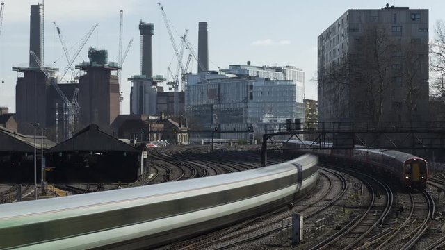 Timelapse shot of trains streaming in and out from Victoria station, Battersea Power Station in background, London, United Kingdom
