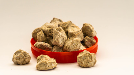 Pile of raw Asam Boi or sour plum on red bowl on white background.