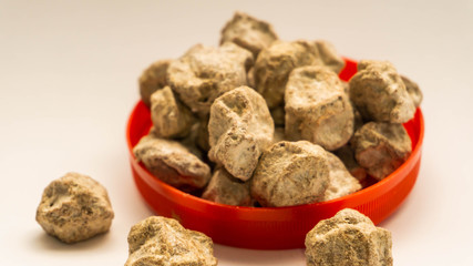 Pile of raw Asam Boi or sour plum on red bowl on white background.
