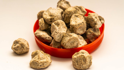 Pile of raw Asam Boi or sour plum on red bowl on white background.