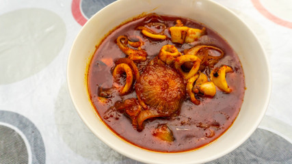 Close up view of Malaysian dish of fried squid with hot and spicy sambal of chili gravy.