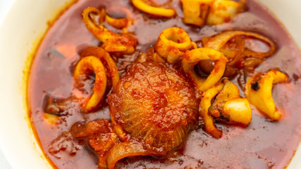 Close up view of Malaysian dish of fried squid with hot and spicy sambal of chili gravy.