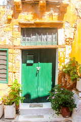 Fototapeta na wymiar Green door to old house in Chania