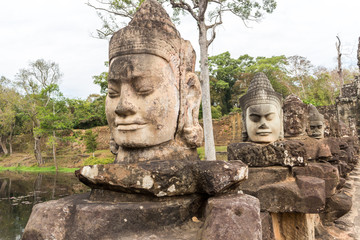 Carved stone Deva heads at Angkor Thom South entrance, Cambodia