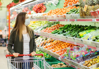 Woman in medical mask shopping in supermarket.