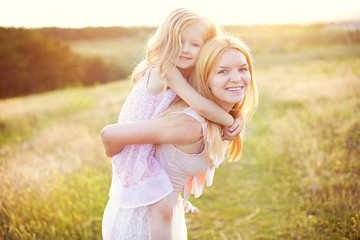 Happy young mother with daughter outdoors.