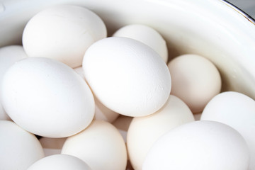 Several white eggs in a Cup close-up.