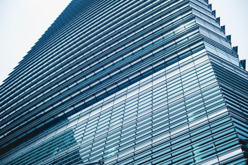 A modern steel and glass office building with clear sky. Wide angle view.