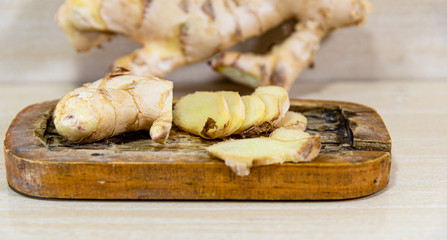 Ginger root (Zingiber officinale) on light and woody background