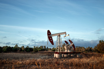 Oil pump, oil rig an industrial oil production standing in the field. Technology concept, fossil...