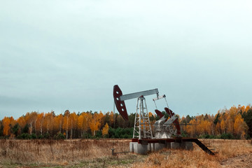 Oil pump, oil rig an industrial oil production standing in the field. Technology concept, fossil...