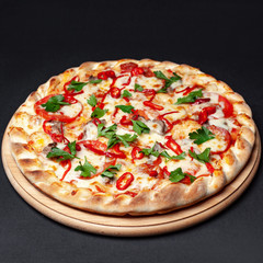 Delicious pizza served on a wooden plate isolated on black