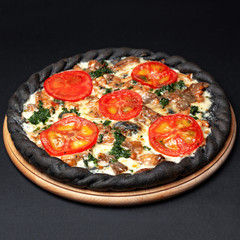 Delicious pizza served on a wooden plate isolated on black