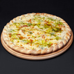 Delicious cheese pizza served on a wooden plate isolated on black
