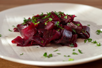 beetroot in a white plate on the wooden table