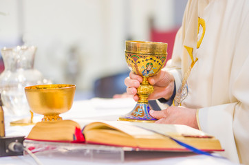 chalice with wine, blood of christ, and pyx with bread, body of christ, ready for the communion of...