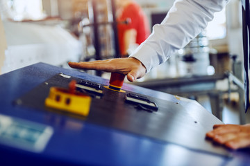 Close up of caucasian supervisor stopping printing machine.