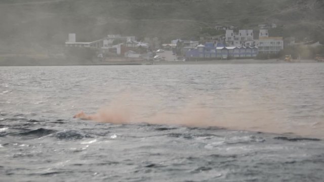 Distress Signal Testing With Orange Flare Smoke In Patagonian Sea During Nautical Training - Medium Shot