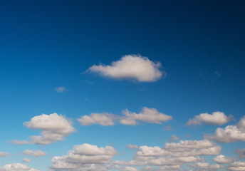 clouds swiftly swim through the blue sky of the day