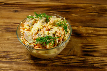 Tasty salad with chicken breast, roasted mushrooms, carrots, grated cheese, eggs and mayonnaise on wooden table