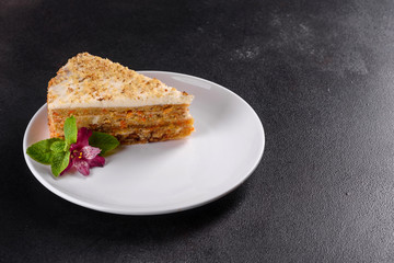 Fresh delicious carrot cake with cream on a dark background