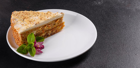 Fresh delicious carrot cake with cream on a dark background