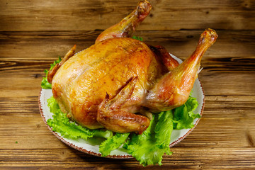 Baked whole chicken on a wooden table