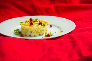 Pineapple salad, decorated with berries on a red background.