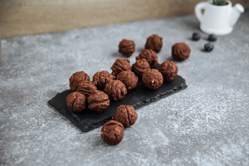Side view on chocolate cookies oreshki nuts with condensed milk on the black board with a cup of tes, horizontal