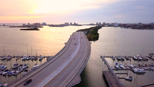 Bridge over the Gulf of Mexico leading to the Clearwater Beach. Summer or spring vacations in Florida. Beautiful ocean sunset. Yacht or boat pier.