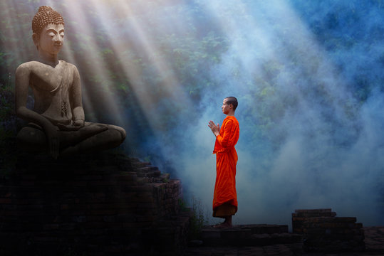 The monks stand to pay respect to the Buddha image.
