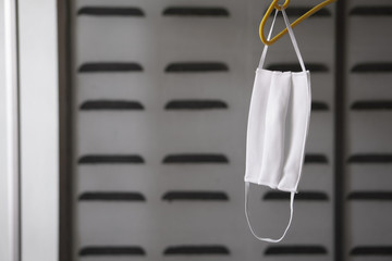 white cloth face mask on clothes hanger for dry after clean wash for close mouth and nose to protect influenza covid 19 virus or bacteria and PM 2.5 dust smoke to cold cough or sneeze by air pollution