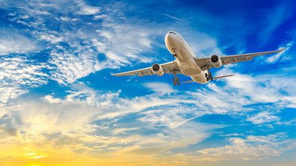 Commercial airplane flying in beautiful sky at sunset,travel concept.