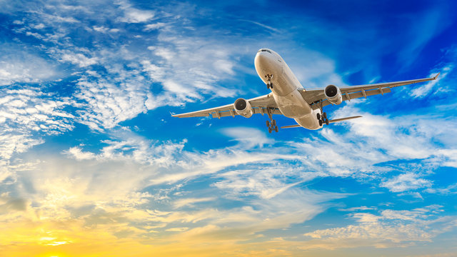Commercial airplane flying in beautiful sky at sunset,travel concept.