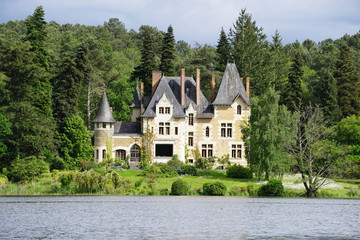 Obraz premium small old stone castle on the lake by the forest in the Loire, France
