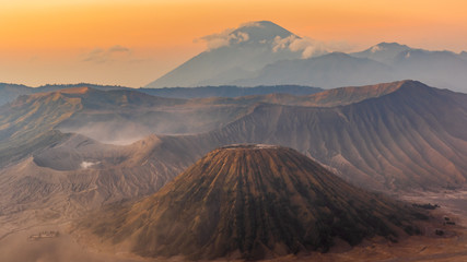 Sunrise over the Mount Bromo and Semeru volcano complex on a red, dusty morning giving the landscape a red, martian appearance