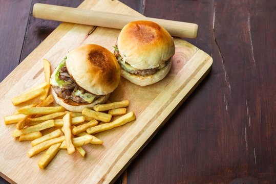 Top image of burgers and fries on a wooden cutting board Is a food that is convenient, uncomplicated and can cook at home.