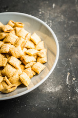 Wholegrain pillow cereals in bowl on the rustic background. Selective focus. Shallow depth of field.