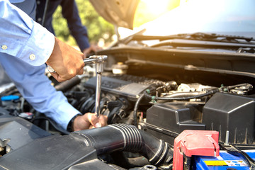 Close up hand of mechanic hands using wrench to repair a car engine. concepts of car insurance support and services.