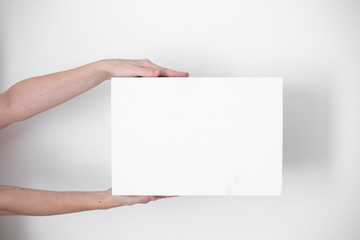 A parcel cardboard box in a delivery man hands on a white background. Delivery service concept.