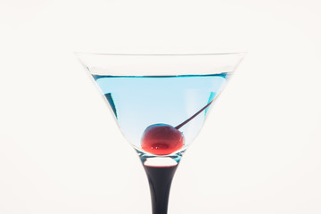 Blue martini cocktail with cherry on the rustic background. Selective focus. Shallow depth of field.