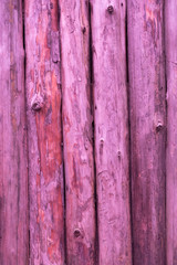 Pink wooden wall made of pine logs as the background texture. the logs are positioned vertically.