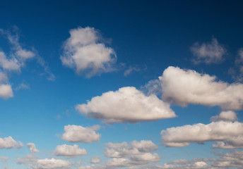 clouds swiftly swim through the blue sky of the day