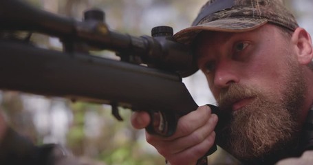 Close up of man hunting in woods with rifle - Powered by Adobe