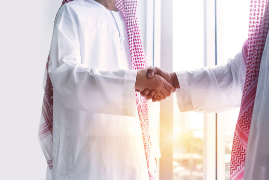 Close up view of two Arab businessmen shake hands after agreement in office, agreement sign concept