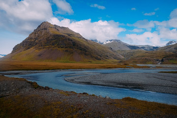 landscape with clear river mountains in the background in Iceland