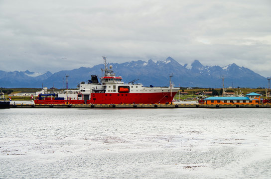 Peruvian research vessel and expedition ship BAP Carrasco with Patagonian mountain range in background in port of Ushuaia, Argentinia sailing Antarctica and other adventurous destinations