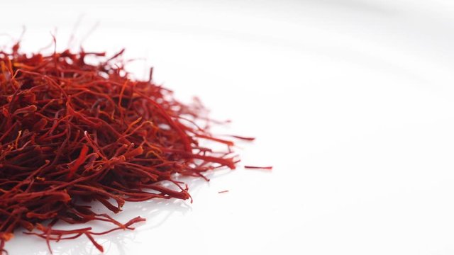 Heap of saffron threads, autumn crocus, isolated on white background. Sideways movement.